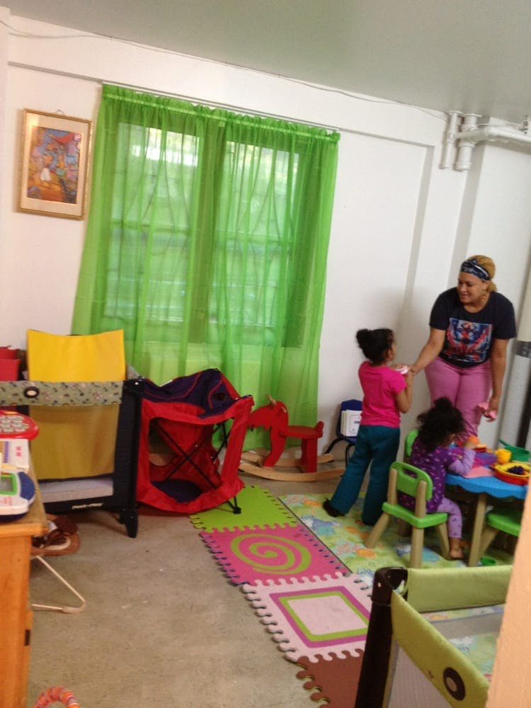 Adult and two children in a room with toys and green curtains