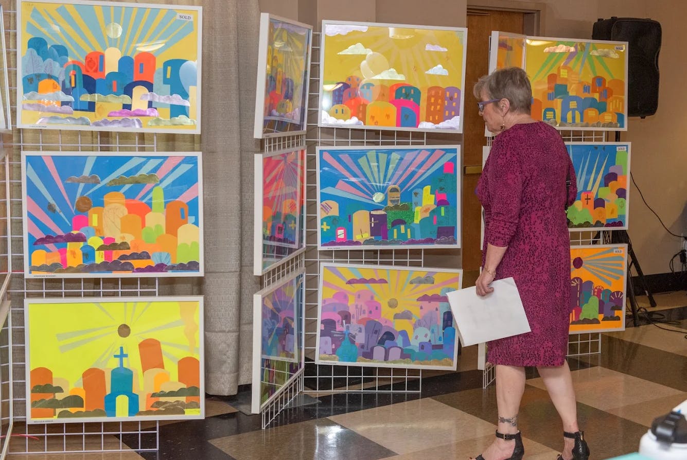 Person viewing colorful artwork displayed on white grids