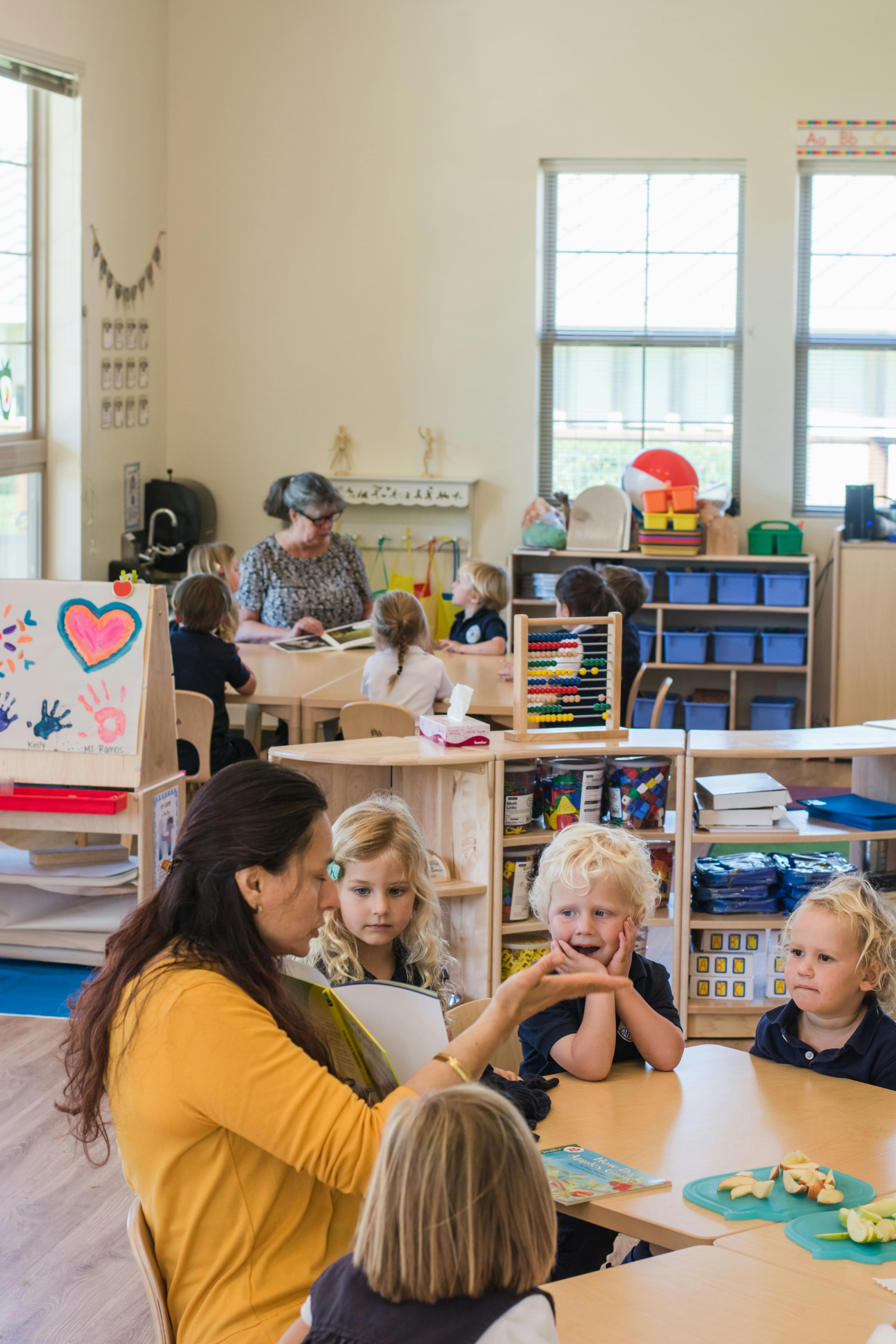 Adult person reading to children in a classroom