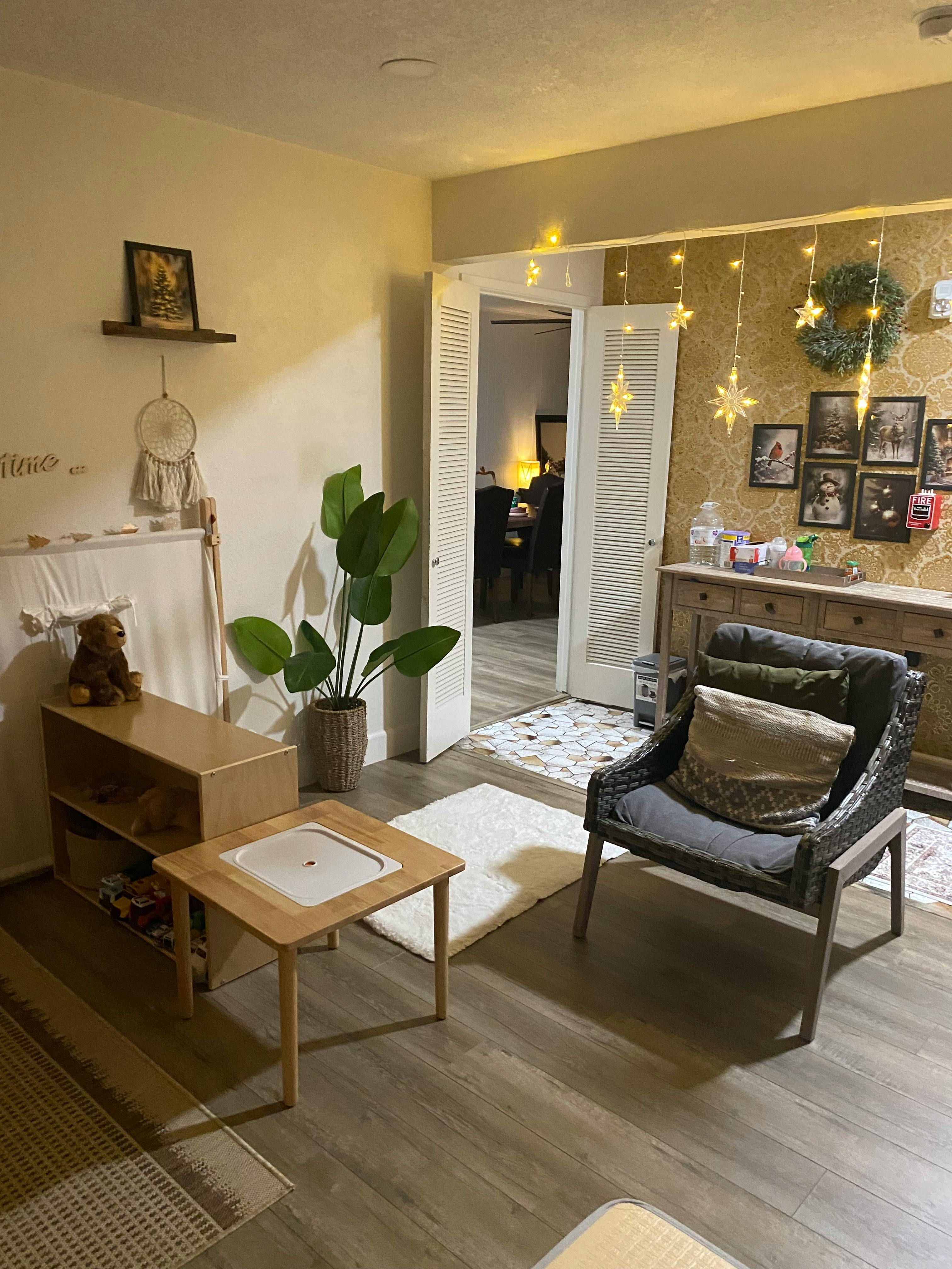 Living room with a plant, small table, and armchair
