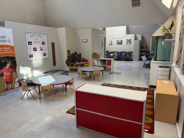 empty classroom with tables, chairs, and learning materials