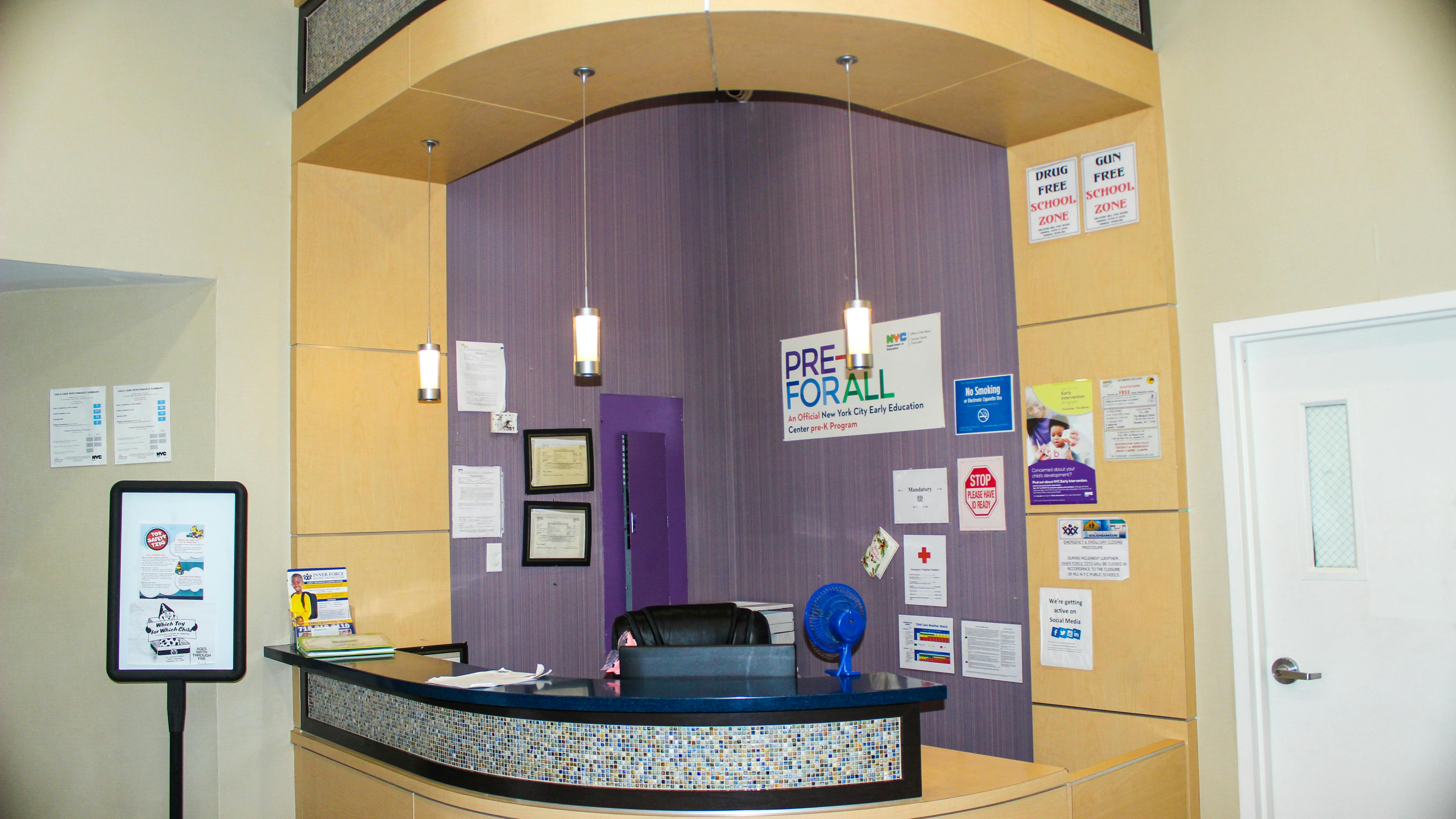 Reception desk with a purple wall and various signs