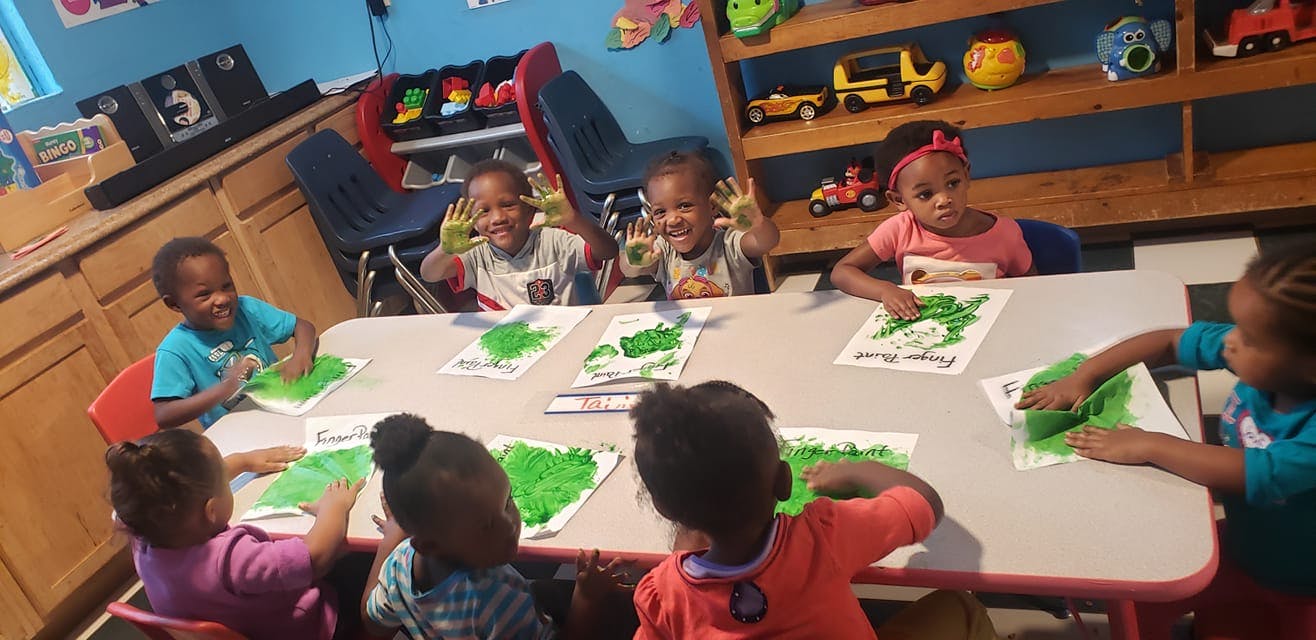 Children sitting at a table doing an art activity