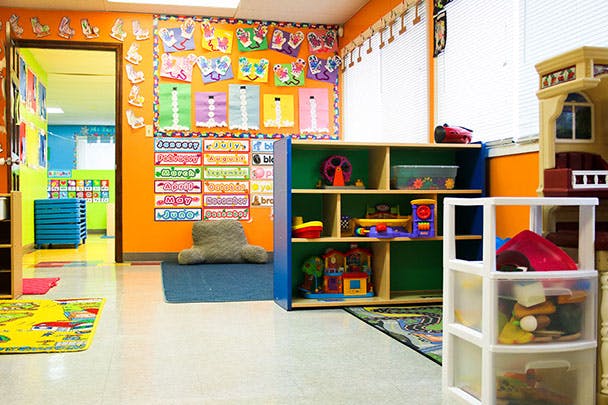 Classroom with colorful walls, shelves of toys, and children's artwork