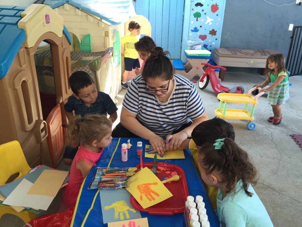 Adult and children doing crafts at a table
