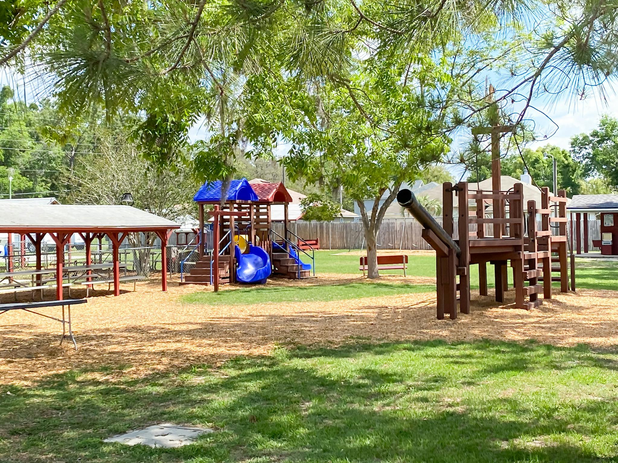 Playground with slides, swings, and a wooden structure