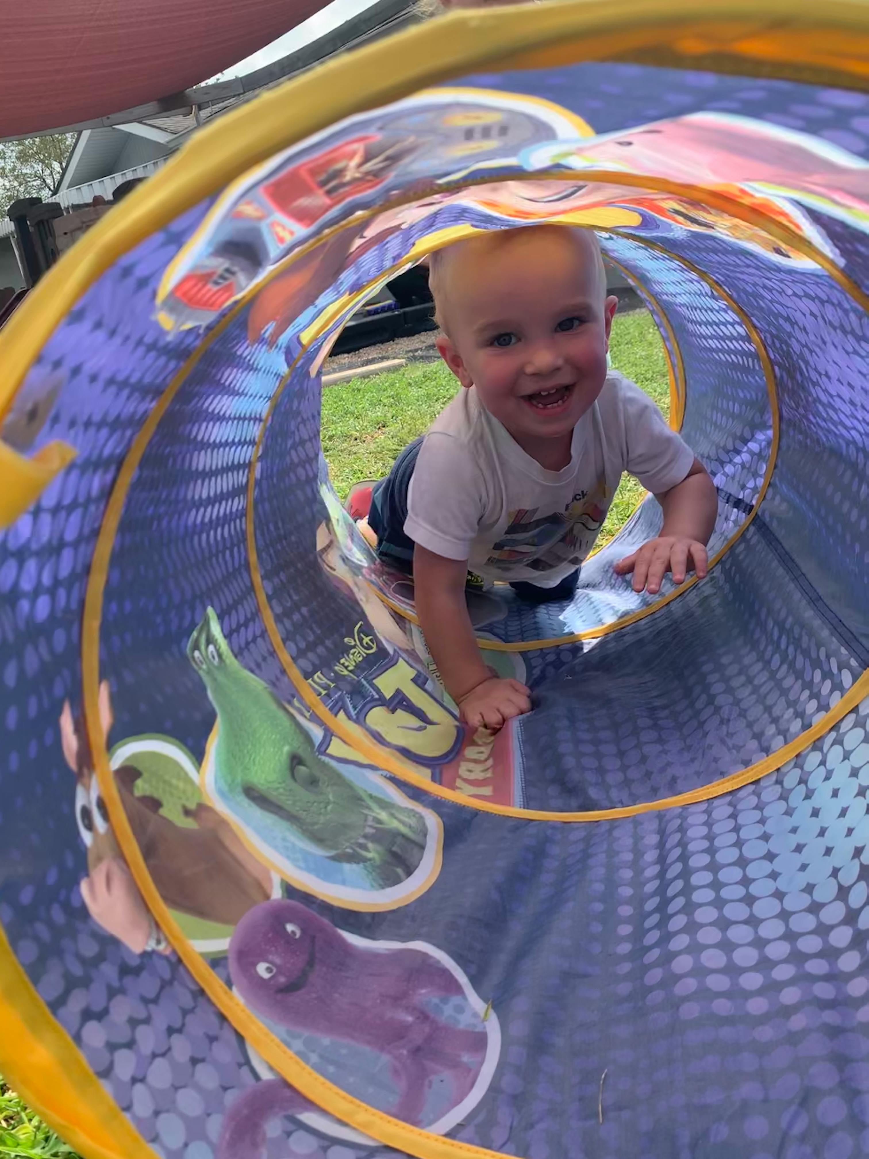 Child crawling through a play tunnel