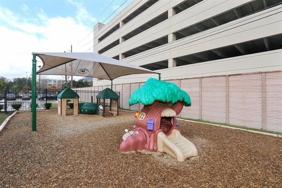 Playground with a tree-shaped slide and shaded play structures