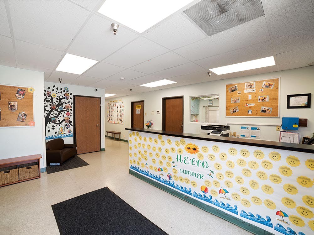 Reception desk with 'Hello Summer' decoration and bulletin boards in a room