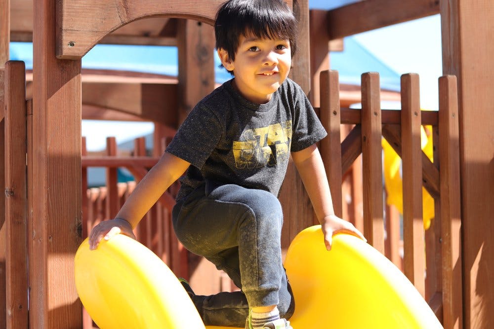 Child on a yellow slide on a playground