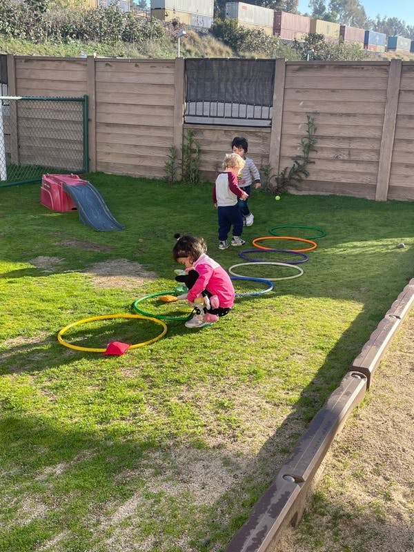 Children playing with hoops on a grassy area