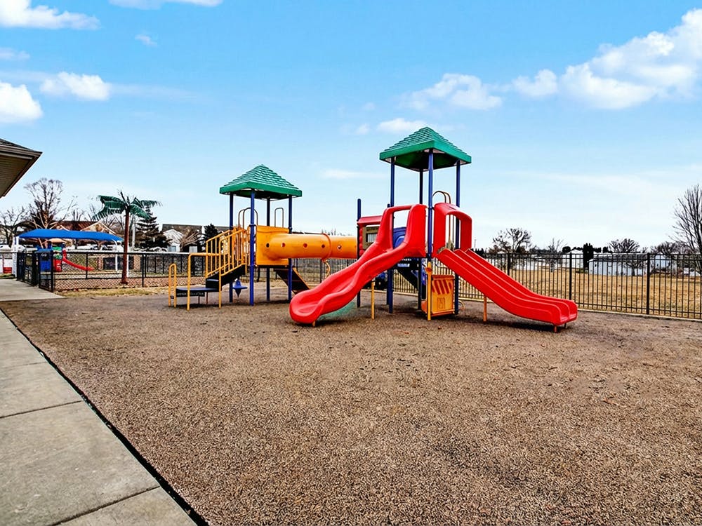 Colorful playground with red slides and yellow tunnels on a sunny day