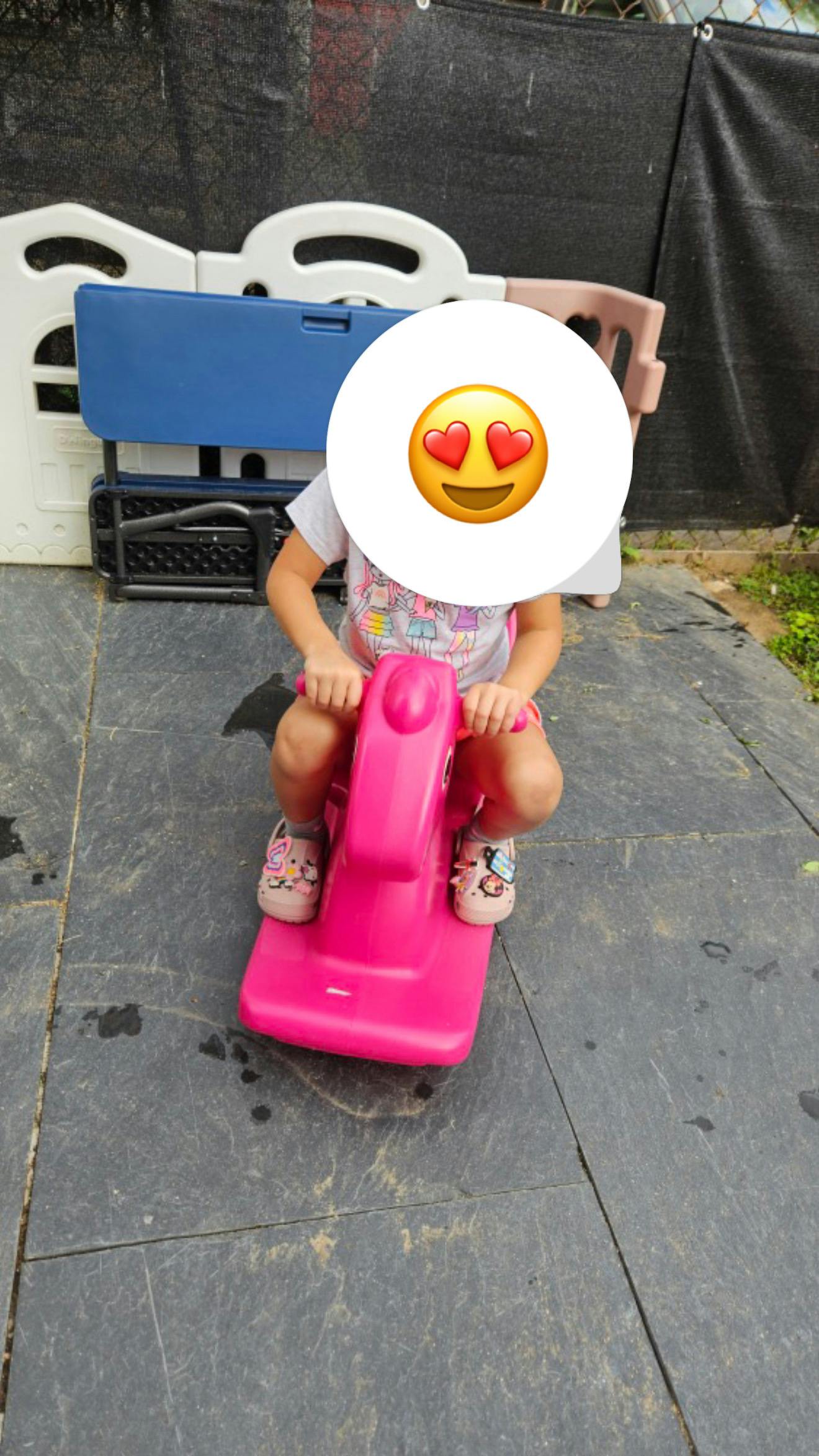 Child on a pink ride-on toy