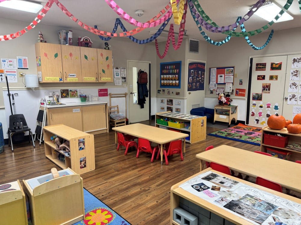 Classroom with tables, chairs, and colorful paper chains hanging from the ceiling