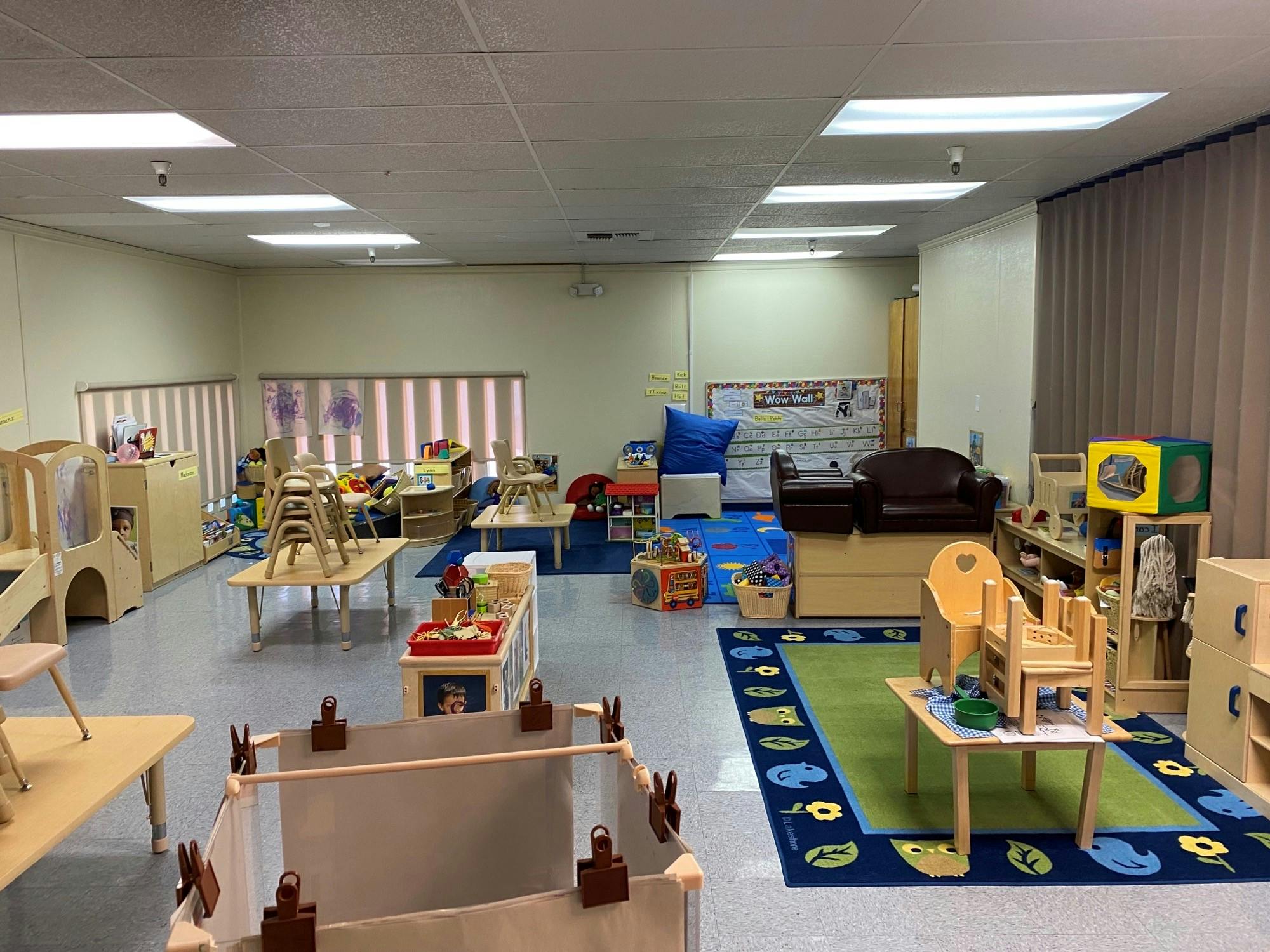 Classroom with small tables, chairs, and play areas
