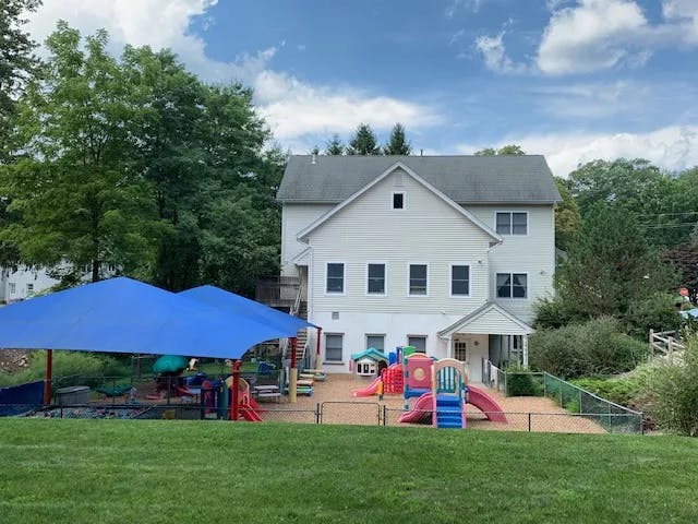 Playground with slides and play structures next to a building