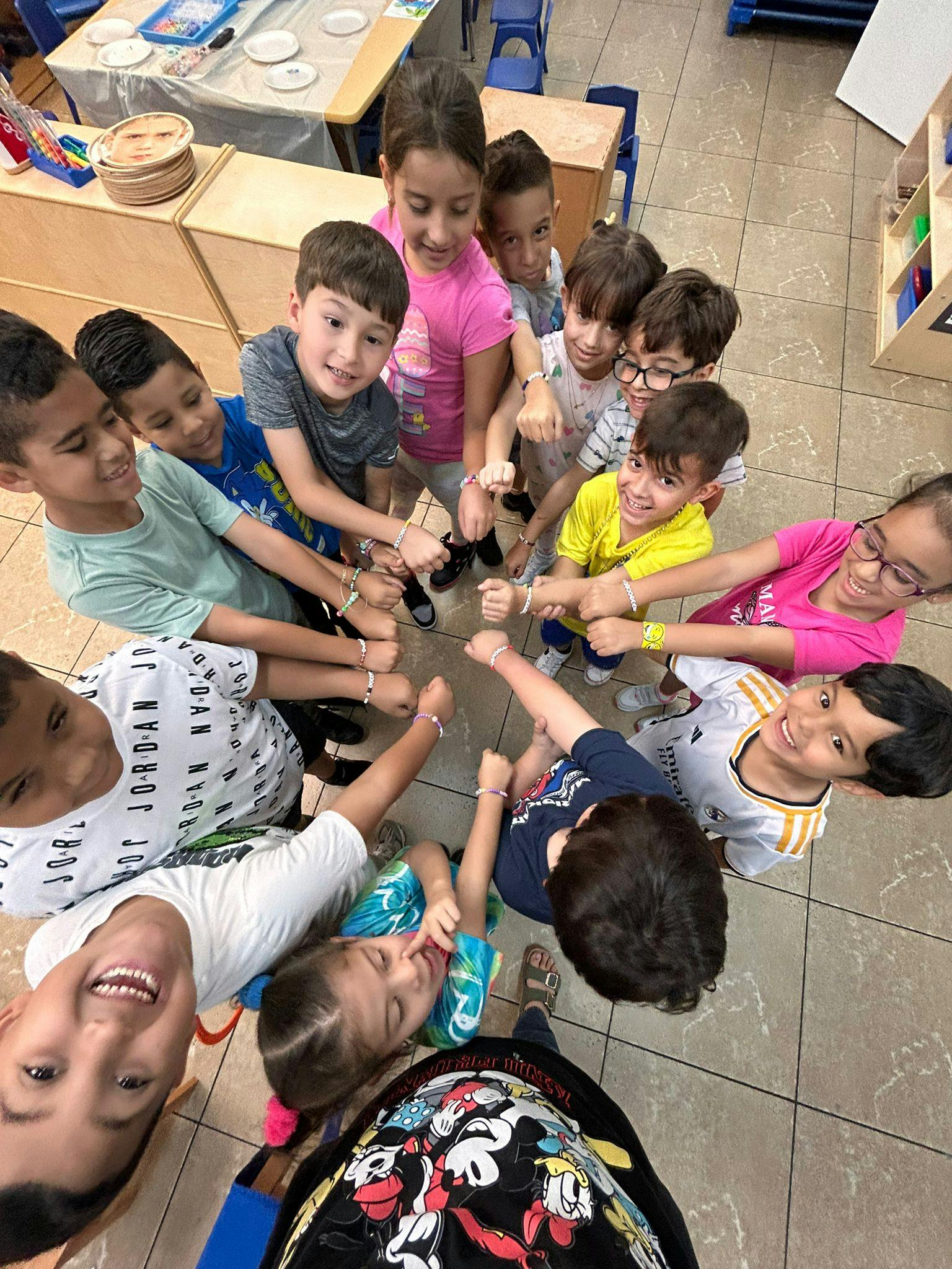 Group of children standing in a circle, holding hands