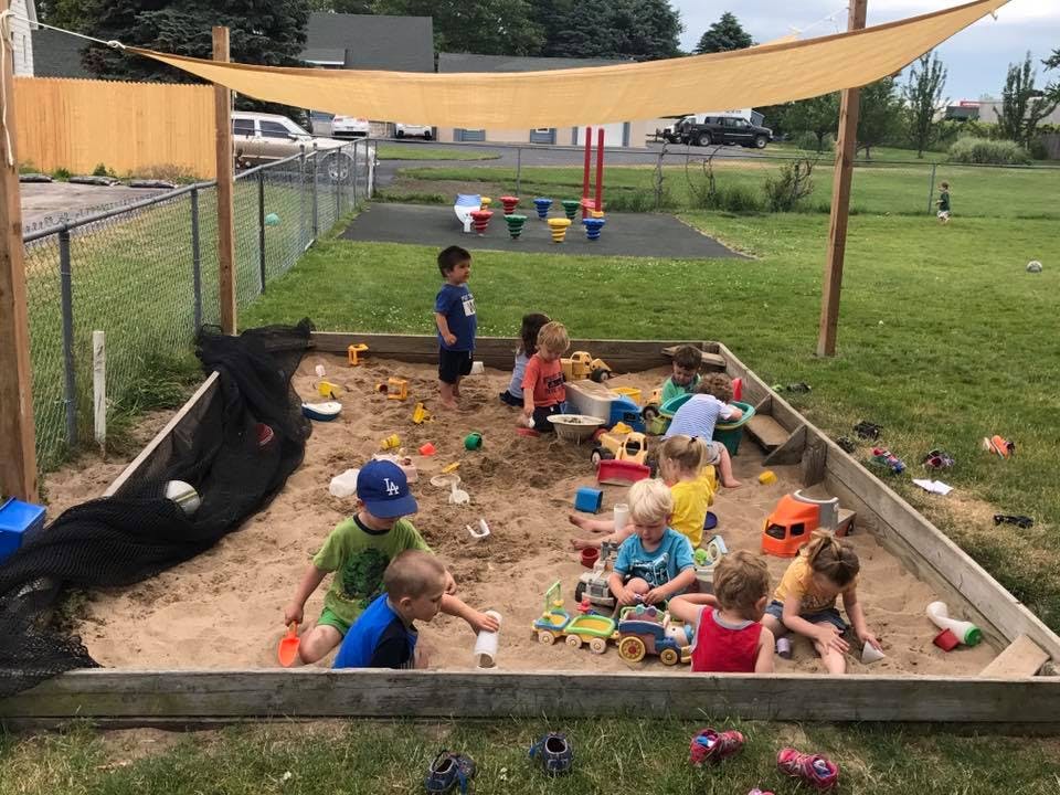 Children playing in a large outdoor sandbox