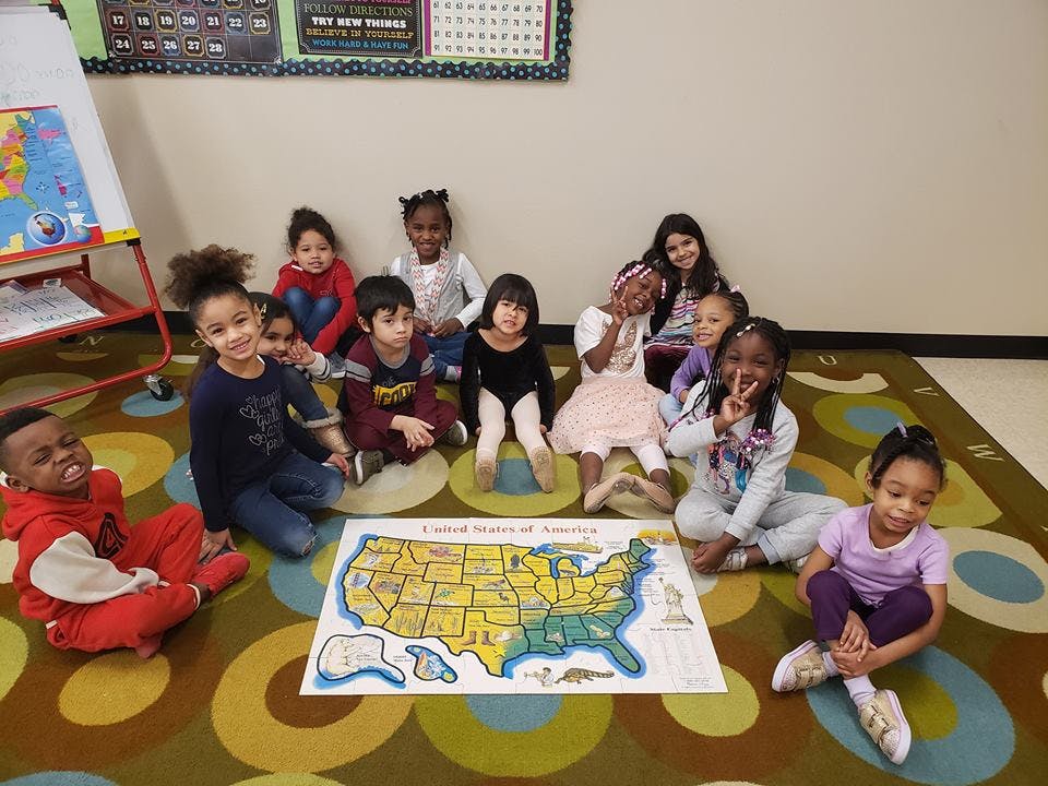 Group of children sitting around a map of the United States