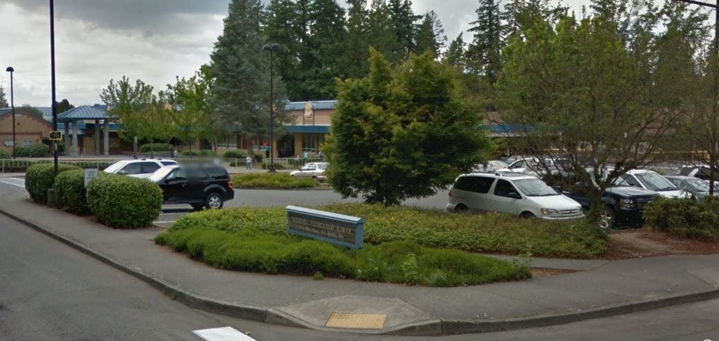 Sign for 'WESLEYHILL ELEMENTARY SCHOOL' in front of a school building and parking lot