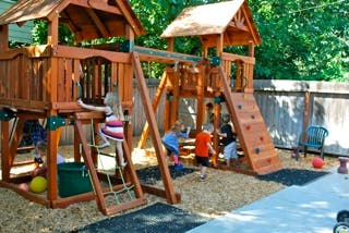 Children playing on a wooden playground structure