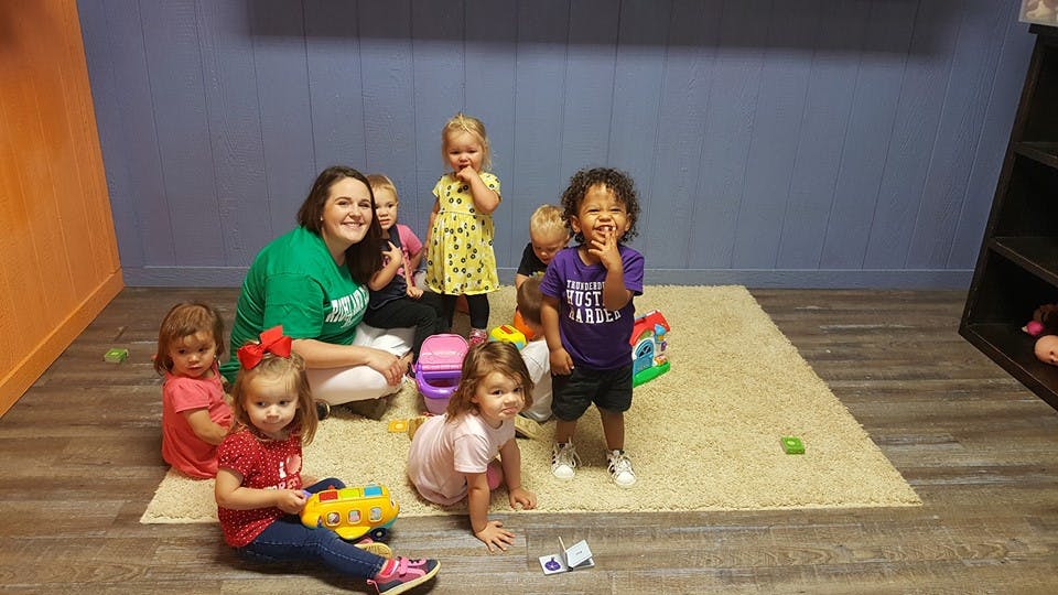 Adult and multiple children on a rug