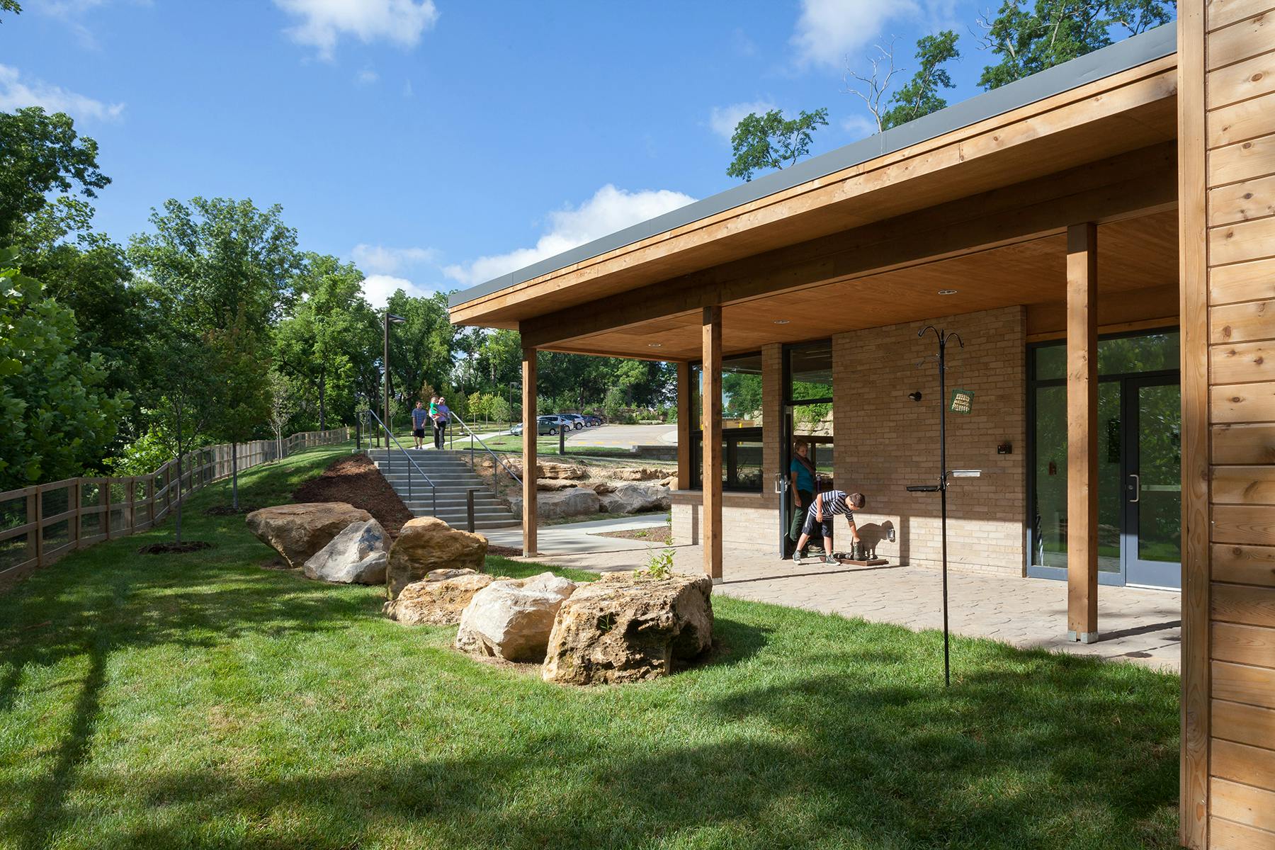 Building with a covered patio and a grassy area with large rocks