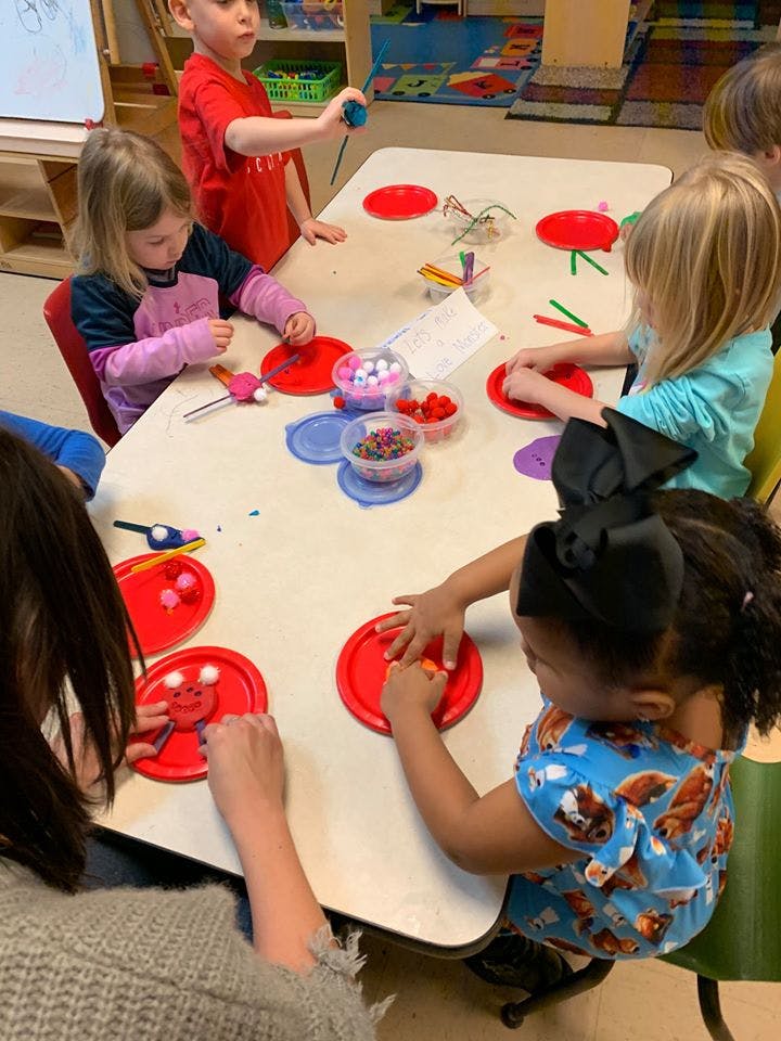 Children at a table doing crafts with craft supplies