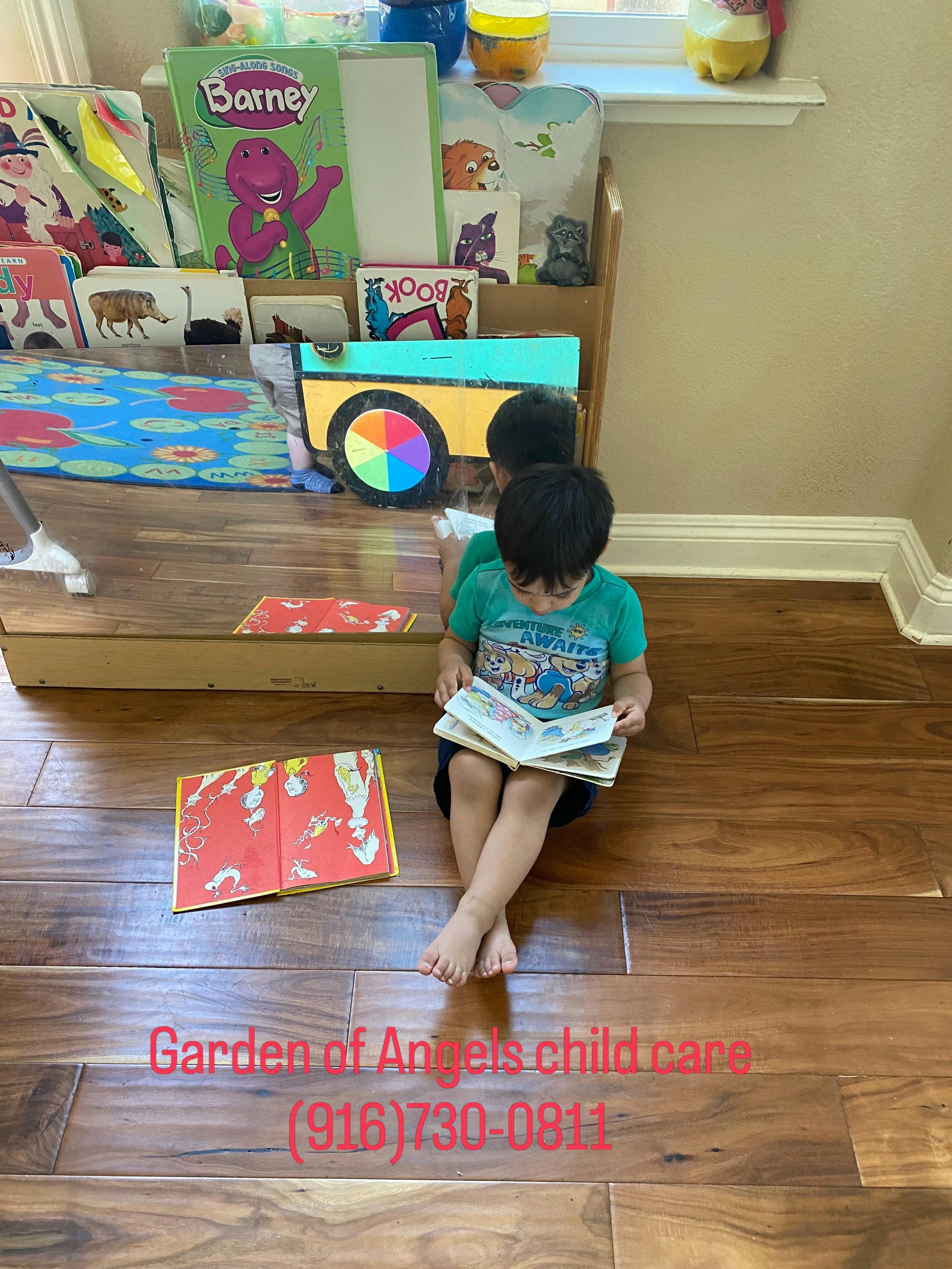 Child sitting on a wooden floor reading a book