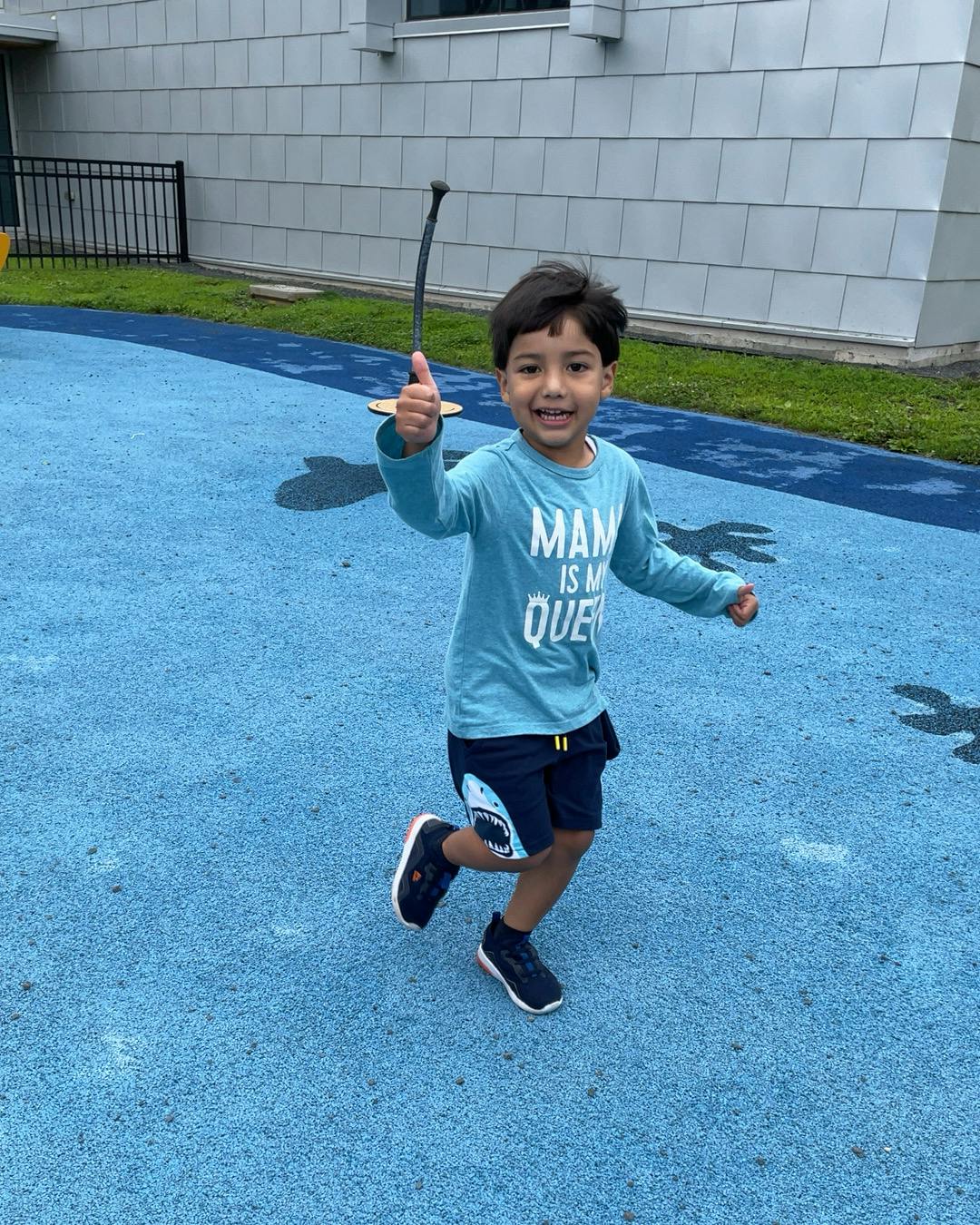Child holding a toy sword and running on a blue surface