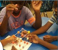 Children building a structure with sticks and balls
