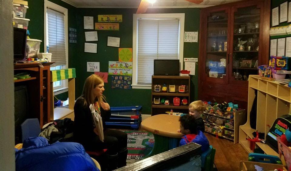 Adult and two children sitting at a table in a room