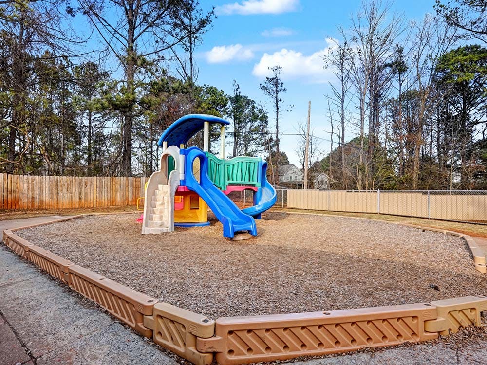 Colorful playground structure with slides on a wood chip ground