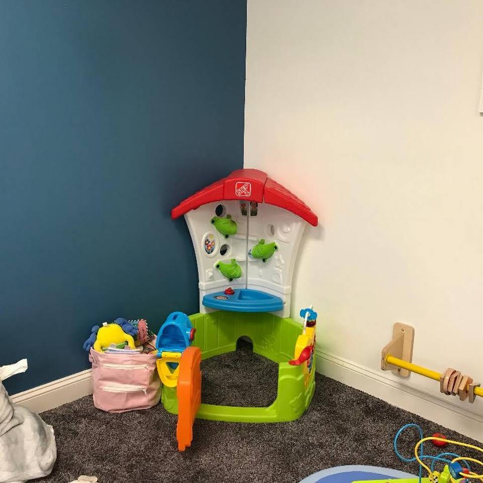 Child's play structure with red roof and green base