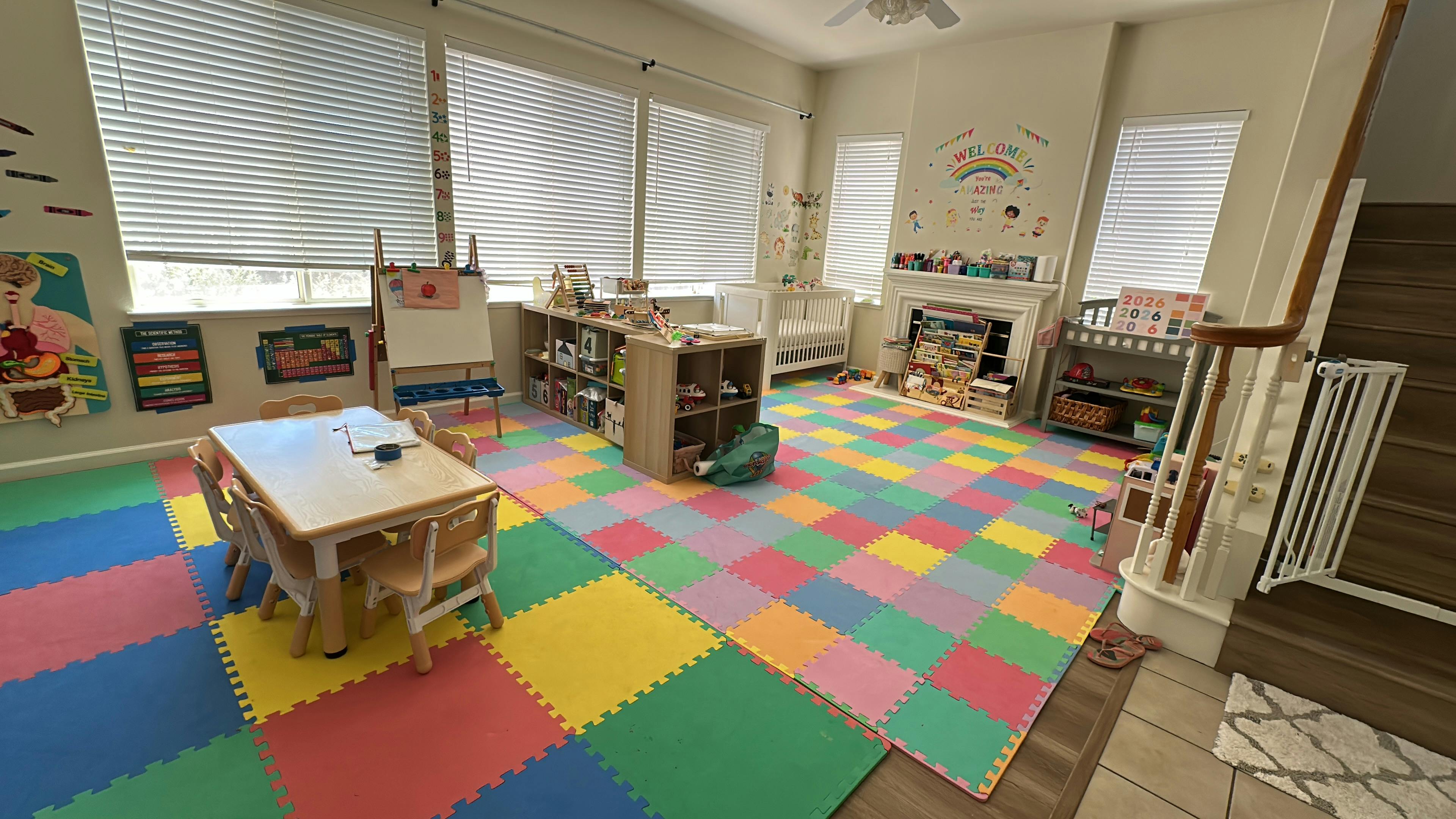 Colorful playroom with a children table, chairs, shelving, and a crib