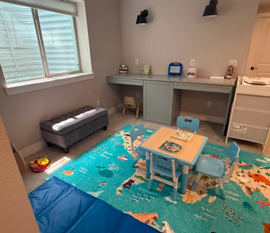 Children's playroom with a world map rug and activity table