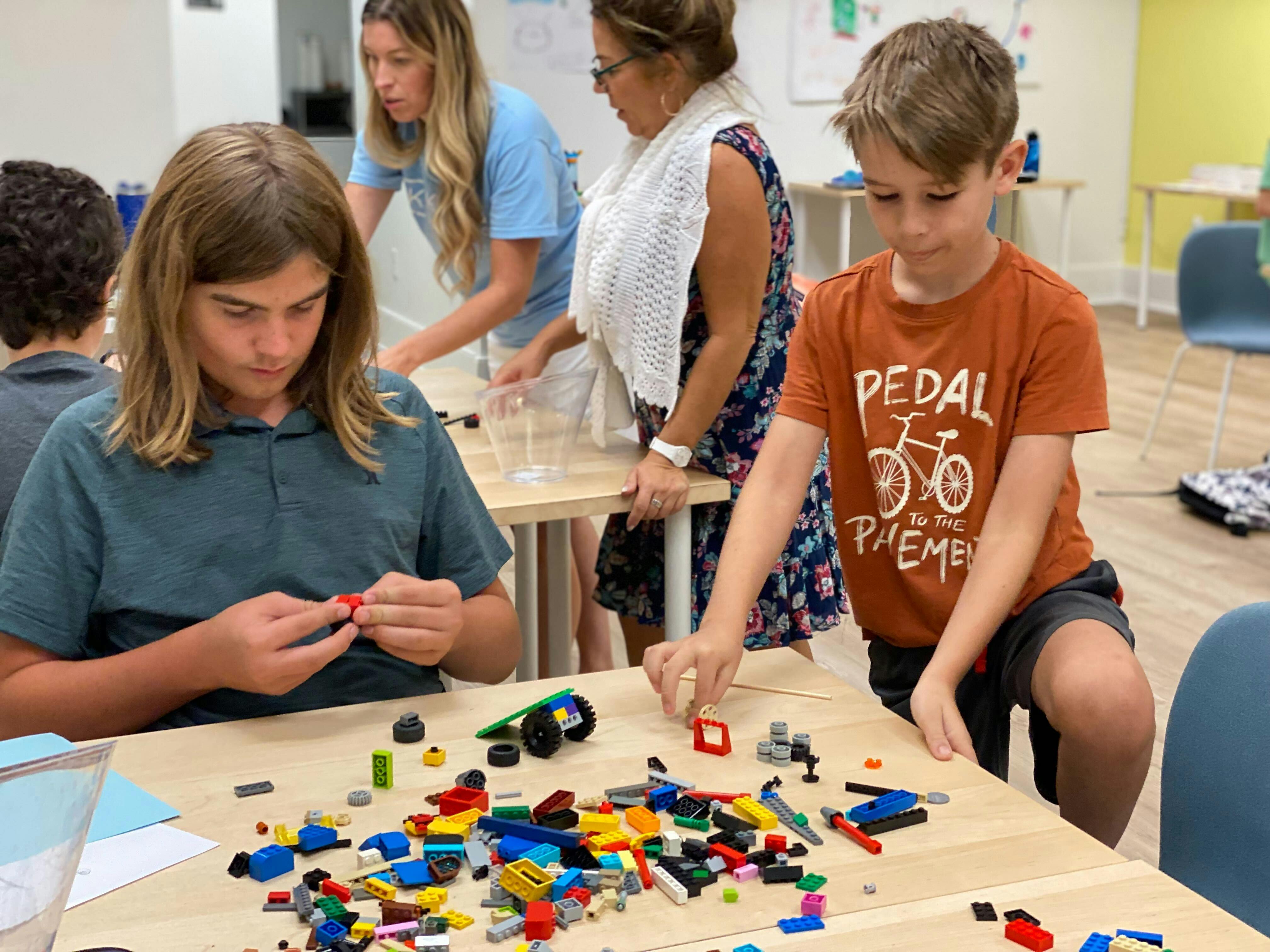 Two children building with colorful toy bricks at a table