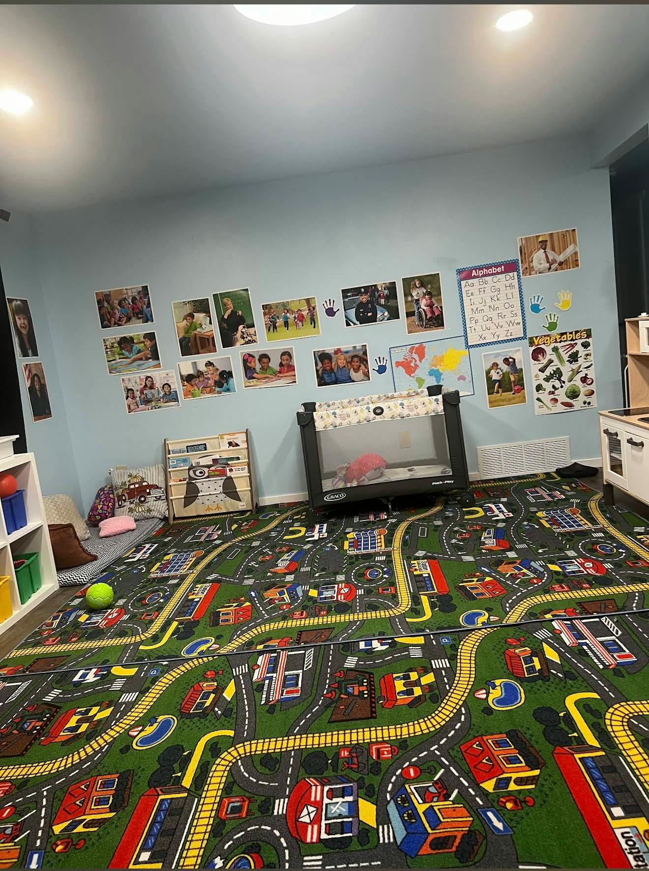 Playroom with a road map rug, wall decorations, and a playpen