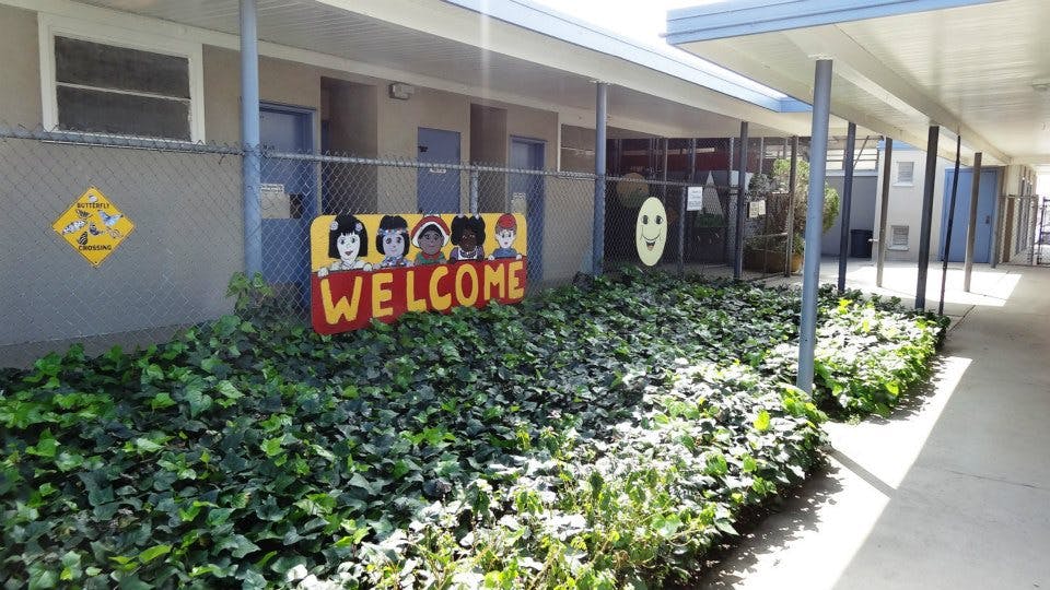 Welcome sign on a fence in front of a building