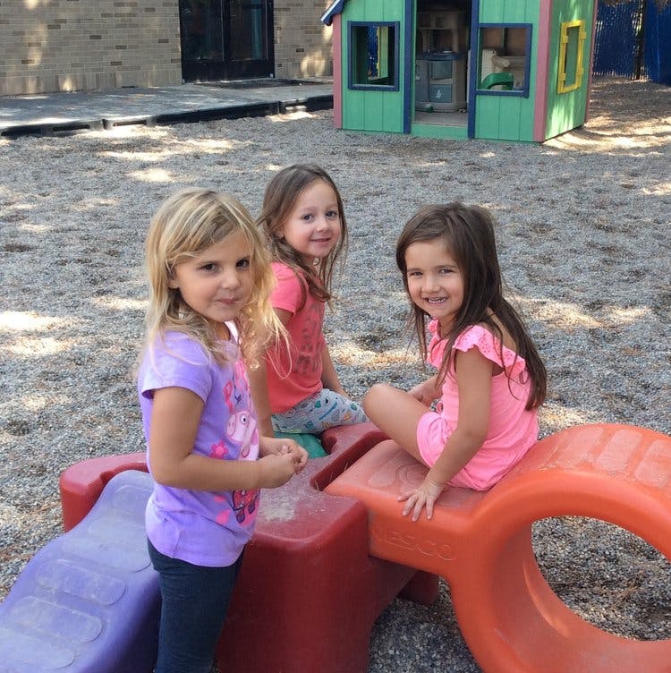 Three children on a playground structure