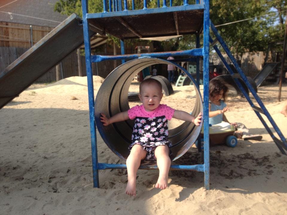 Child sitting in a tunnel on a playground