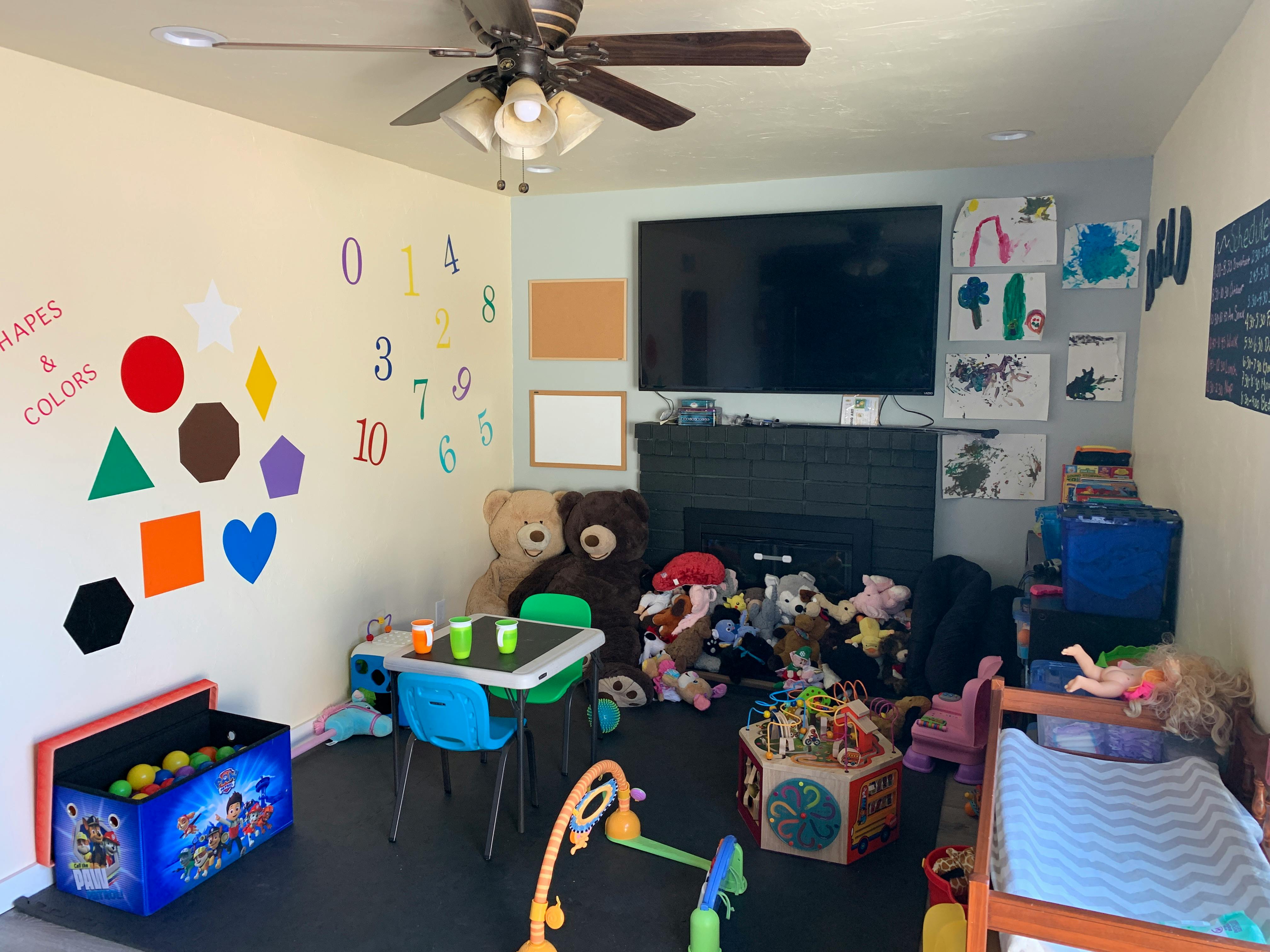 Playroom with toys, small table and chairs, and wall decorations