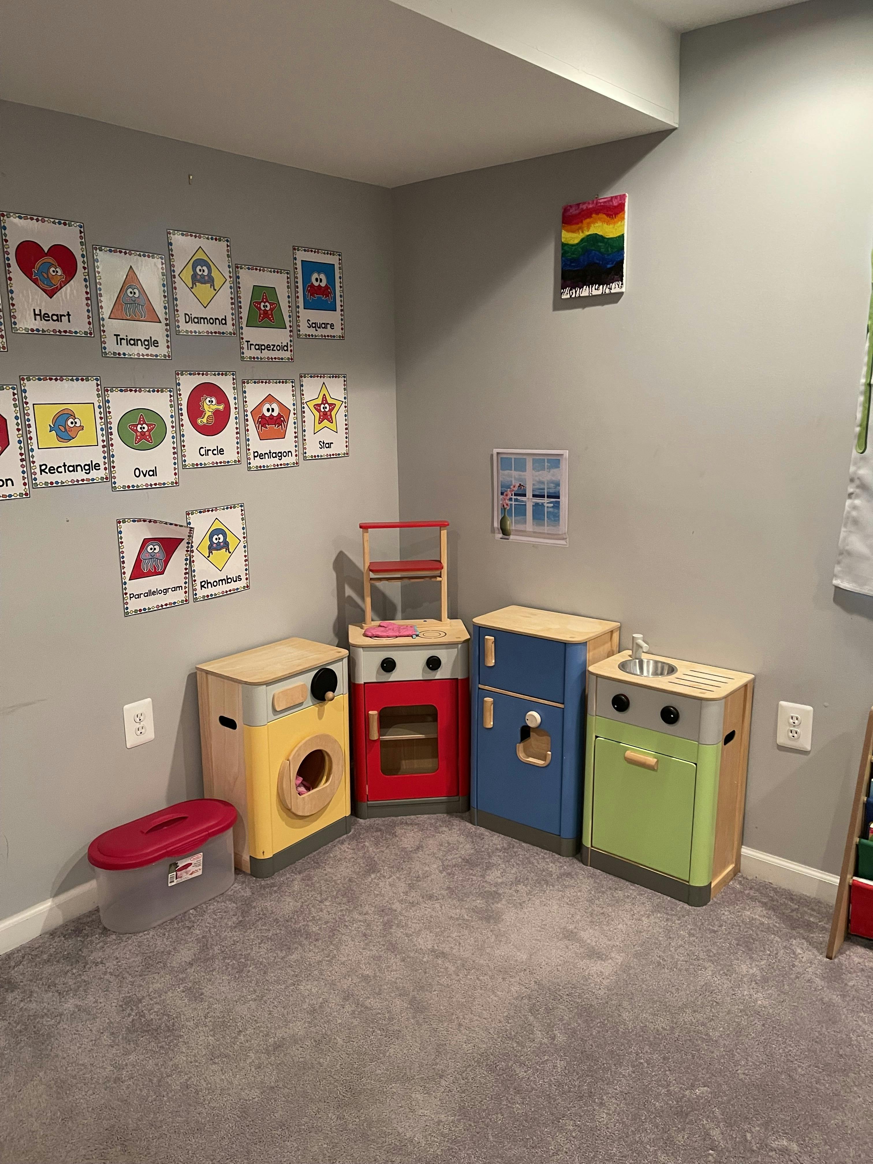 Children's play kitchen set with a refrigerator, stove, washer, and sink