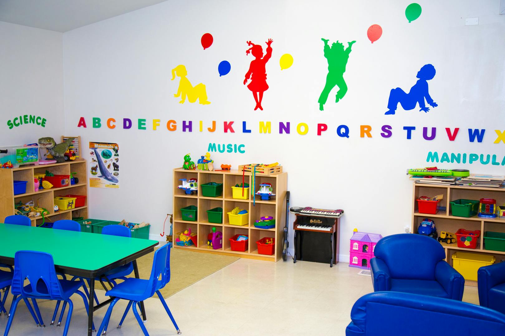 Classroom with colorful wall decorations, shelves, tables, and chairs