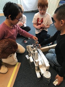 Children playing with toy cars and a ramp