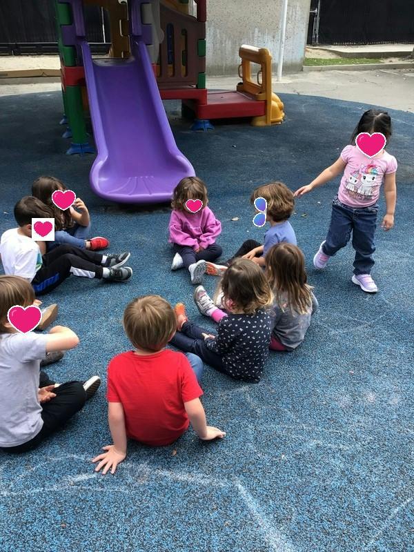 Children sitting in a circle on a playground