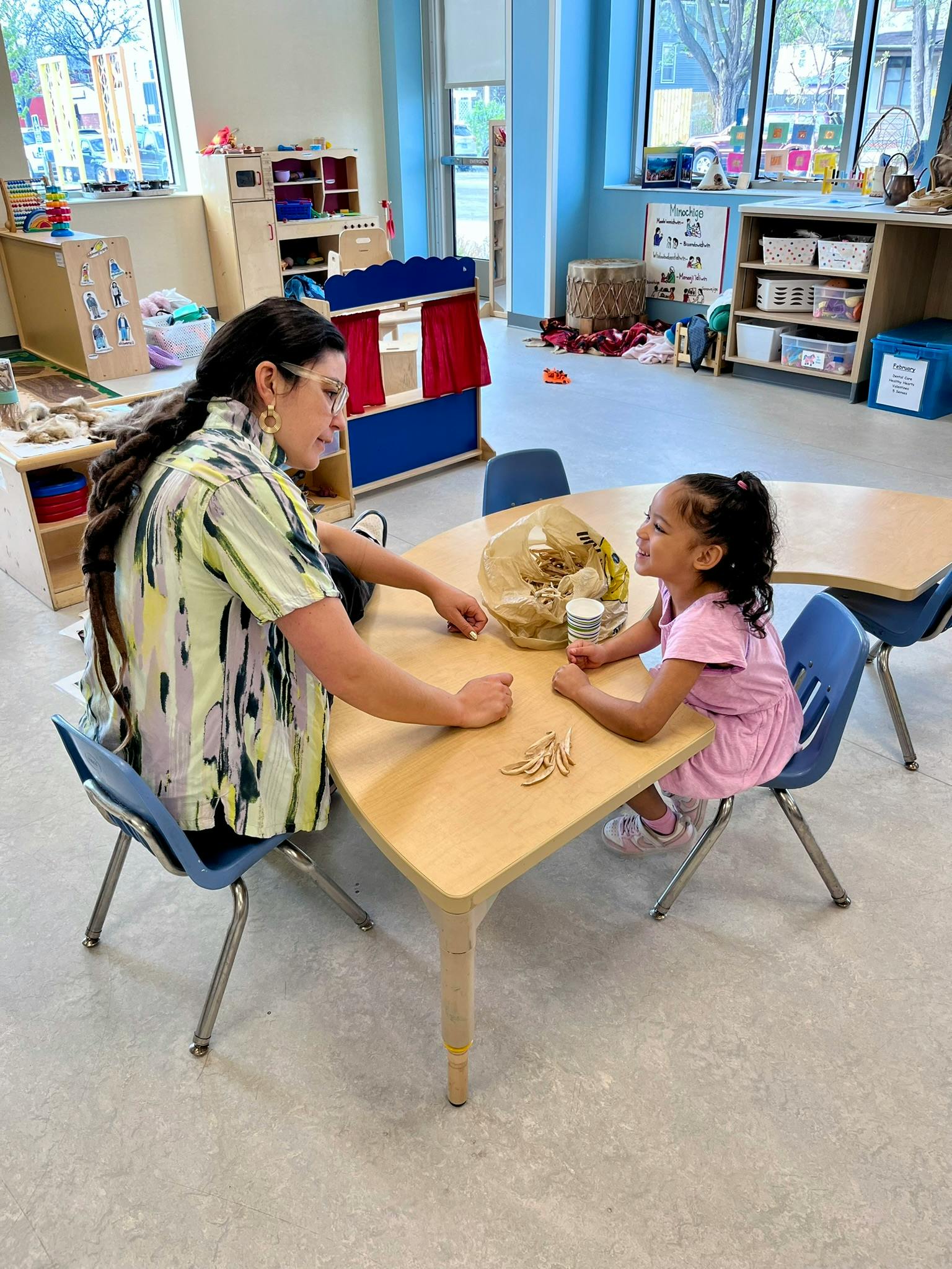 Person and child at a table in a classroom