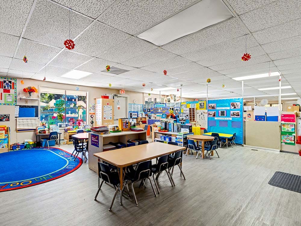 Empty classroom with tables, chairs, and colorful decorations