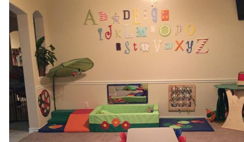 Playroom with alphabet letters on wall and soft play equipment