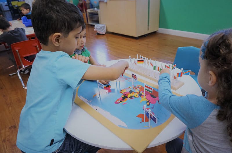 Two children playing with a toy set on a table